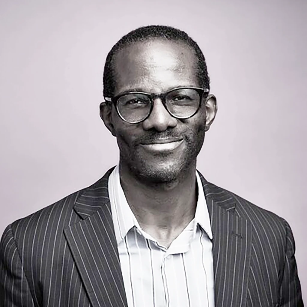 black and white head shot of Chaney Ojinnaka, black male in his mid 30's for the blog post announcing his addition to PRC's staff and board section of our website. Chaney is on PRC's Board of Directors