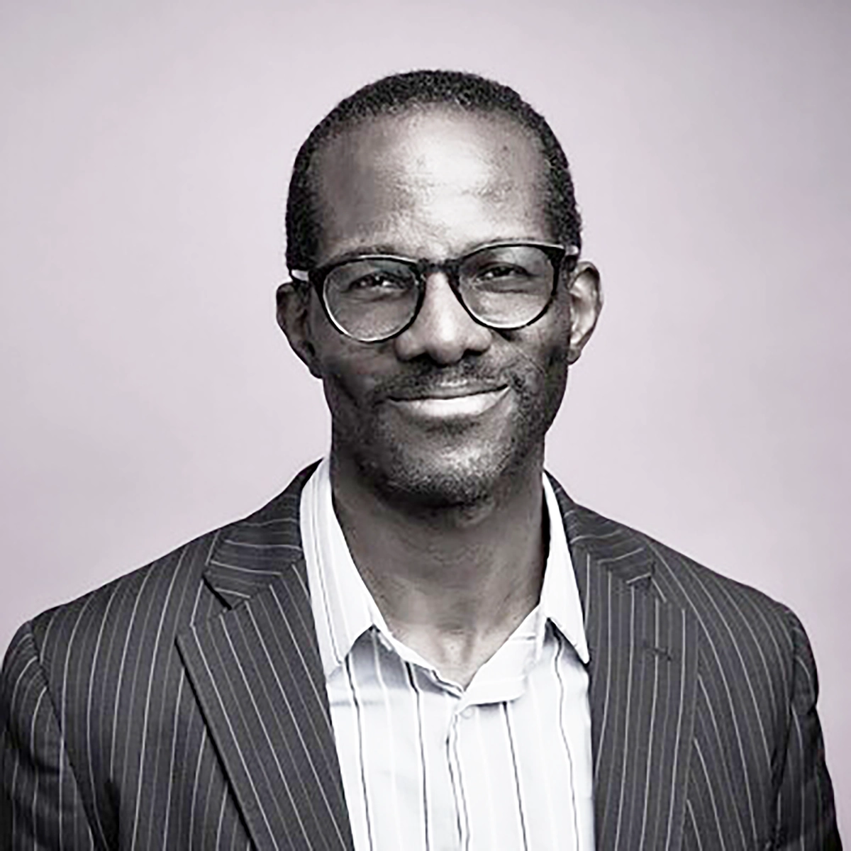 black and white head shot of Chaney Ojinnaka, black male in his mid 30's for the blog post announcing his addition to PRC's staff and board section of our website. Chaney is on PRC's Board of Directors